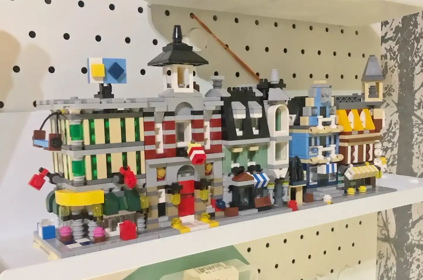Shelf display of colorful Lego buildings with various mini Lego figures and details.