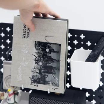A speaker, remote, and album on the Plastic Desk Pegboard