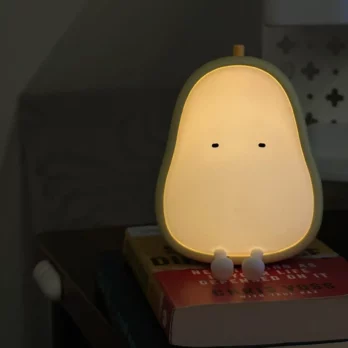 Yellow pear night light placed on top of a book